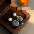 Pair of earrings with gemstones in a wooden box