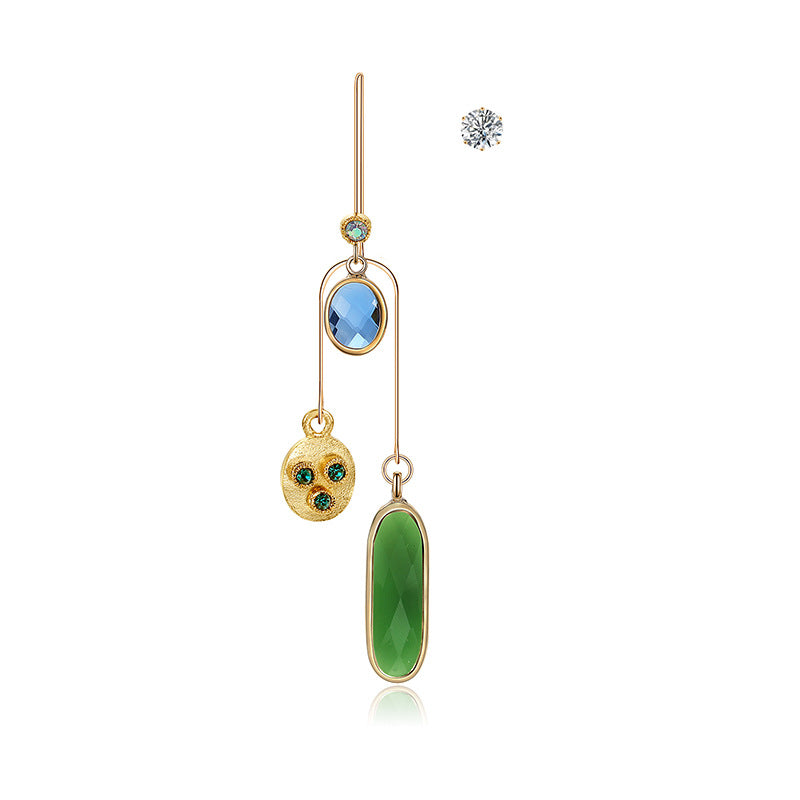 Gold earrings with green and blue gemstones on a white background