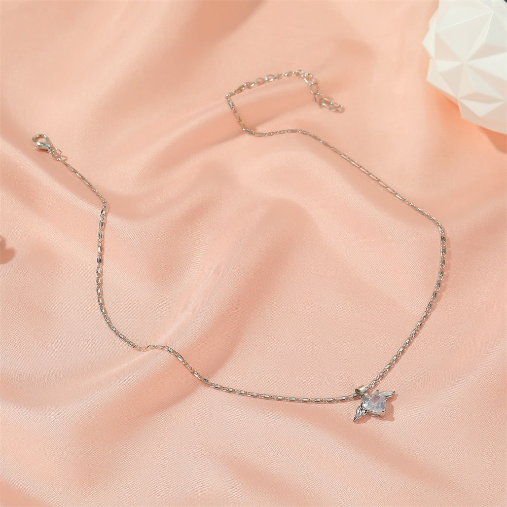 Silver necklace with a star-shaped pendant on a soft pink fabric background