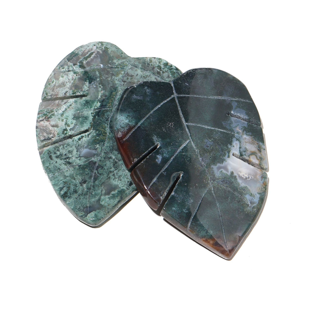 Two heart-shaped green stones with a white background