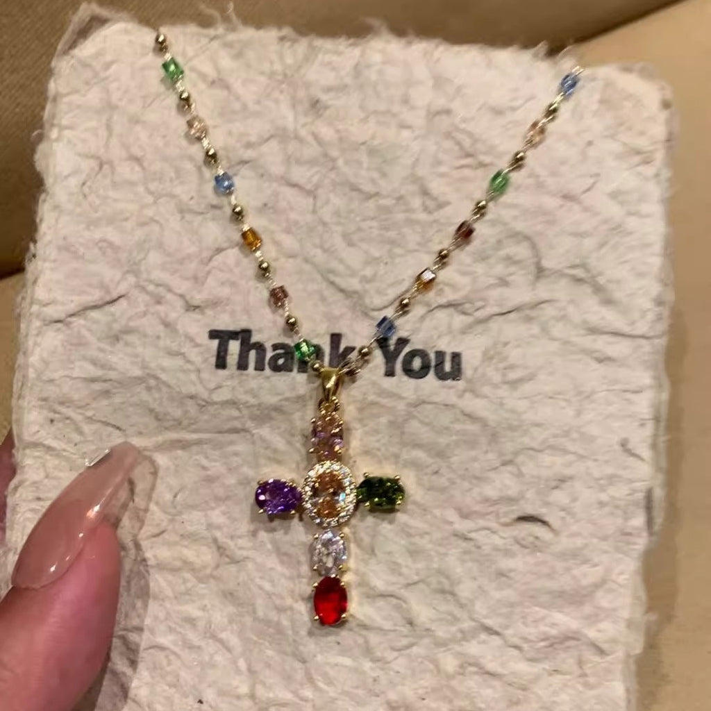 Colorful beaded necklace with a cross pendant on a 'Thank You' card.