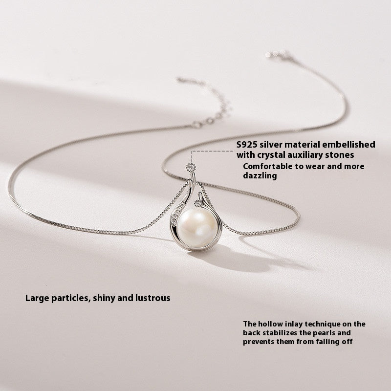 Silver necklace with a pearl pendant on a light background