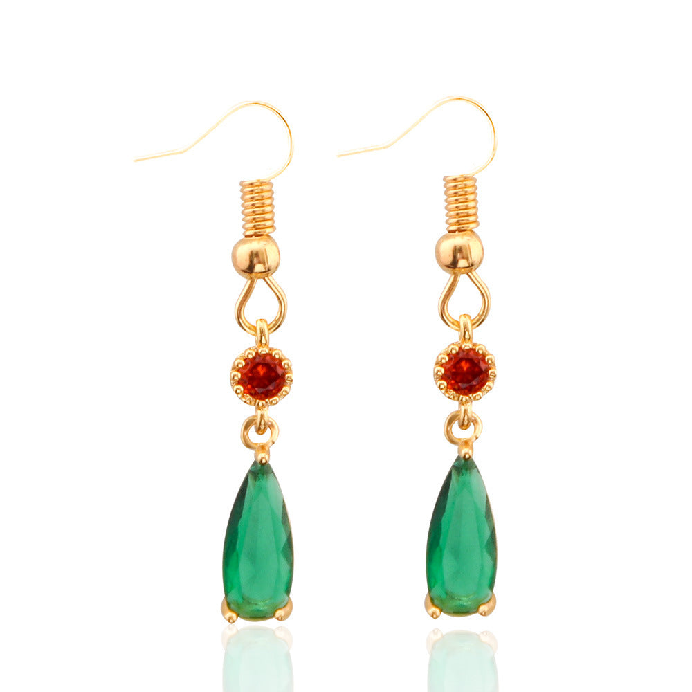 Gold earrings with green teardrop and red gemstone drops on a white background