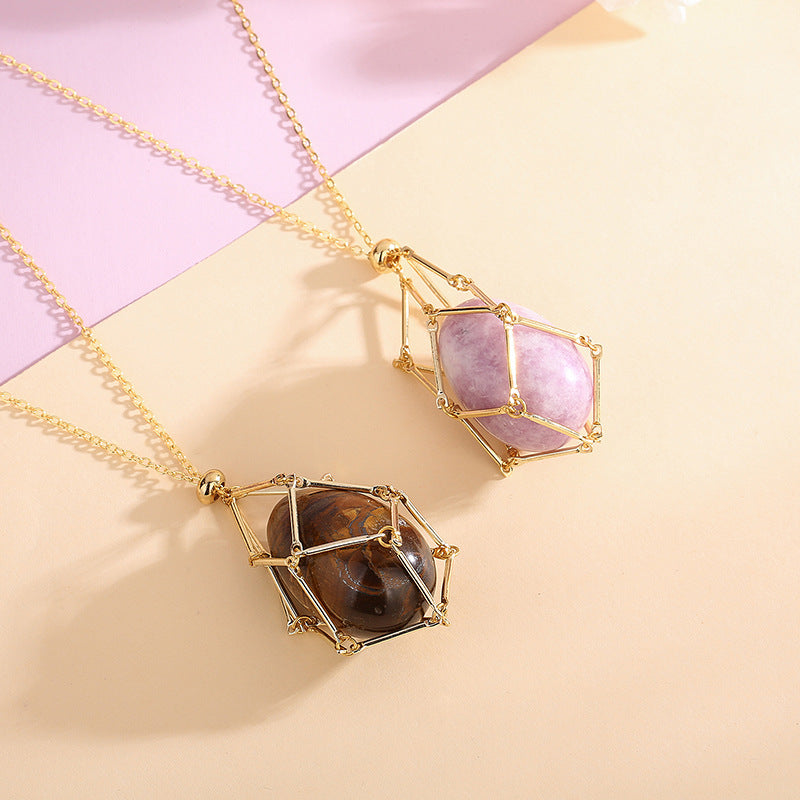 Two gold necklaces with gemstone pendants on a pink and beige background