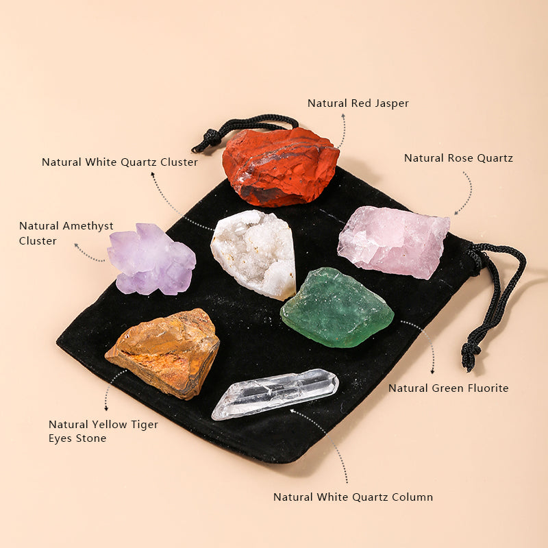 Set of various crystals including White Quartz Cluster, Red Jasper, Rose Quartz, Amethyst Cluster, Green Fluorite, Yellow Tiger's Eye, and White Quartz Column on a black drawstring bag.