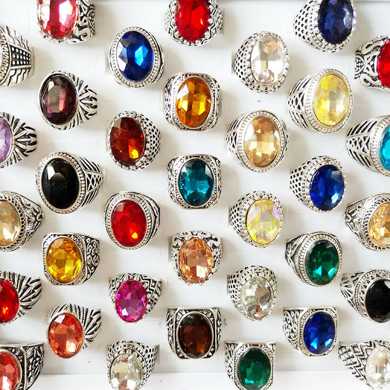 Collection of colorful gemstone rings on a white background