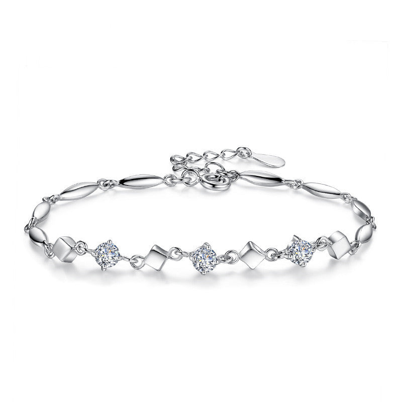 Silver bracelet with diamond accents on a white background