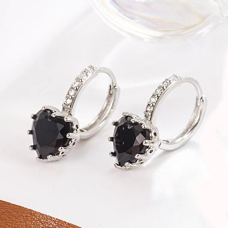 Silver earrings with black gemstones on a white background