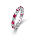Silver ring with red gemstones on a white background