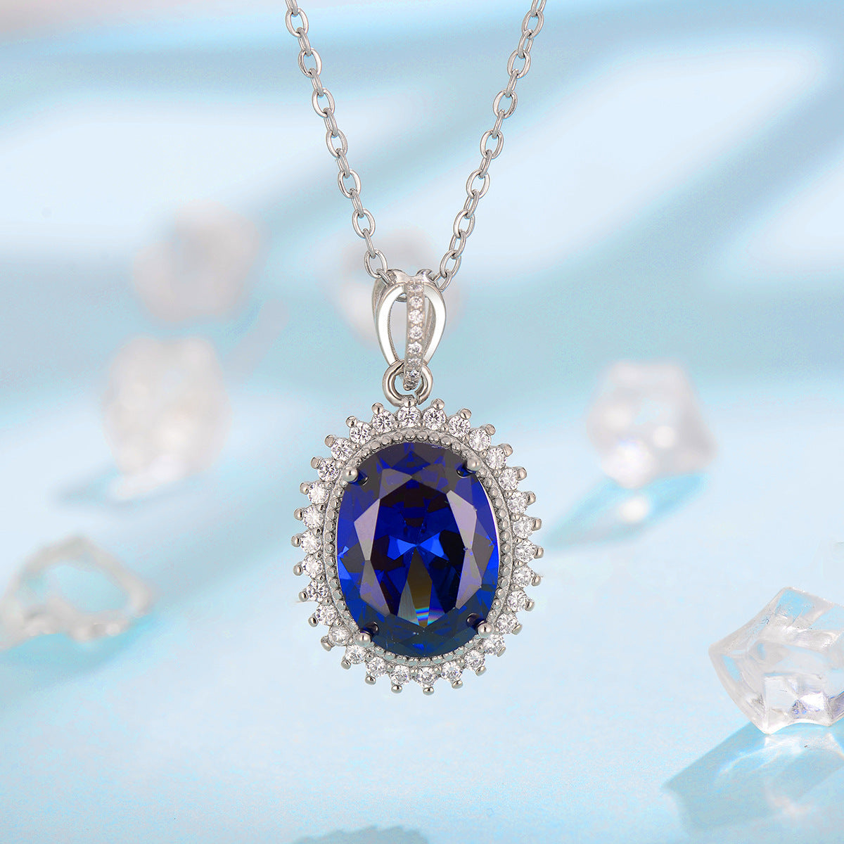 Silver necklace with a blue gemstone pendant on a light blue background