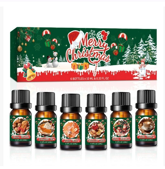 Set of Christmas-themed essential oil bottles with a decorative box in the background.