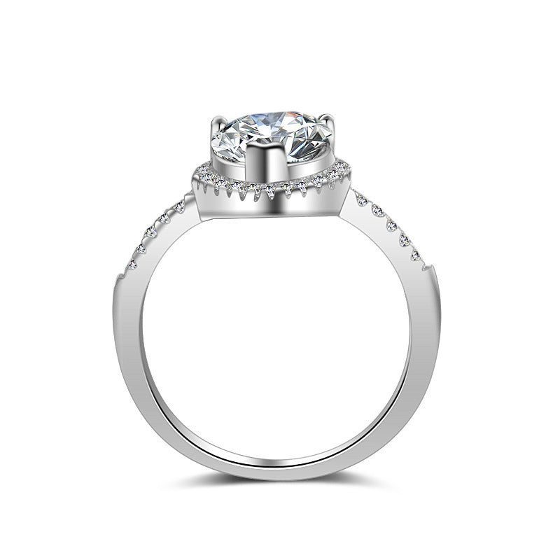 Silver ring with a large central diamond and smaller diamonds on the band against a white background