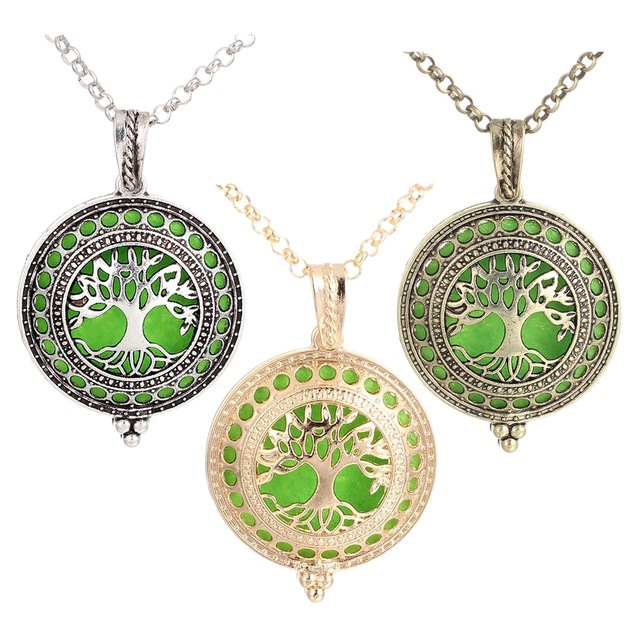 Three tree-of-life pendants in silver, gold, and bronze on a white background