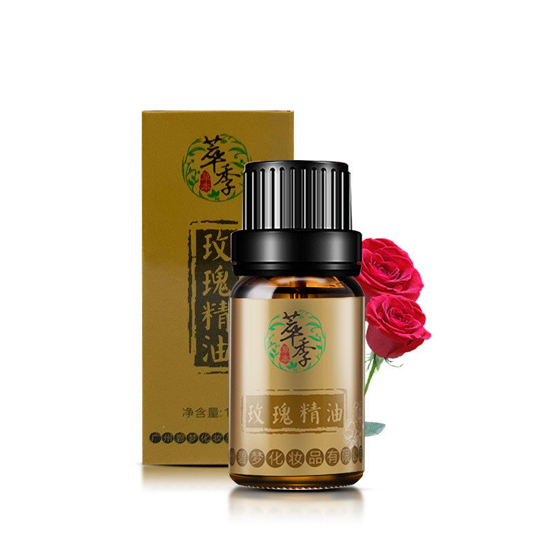 Bottle of rose essential oil with packaging and a rose on a white background