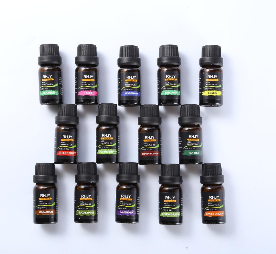 Collection of 18 small bottles of RHUY essential oils on a white background