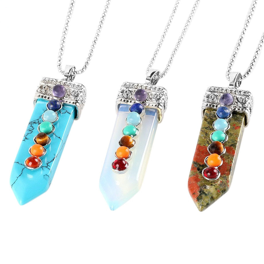 Three colorful stone pendants on silver chains against a white background