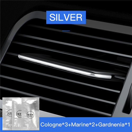Car air vent with a silver strip and cologne packets labeled 'Cologne', 'Marine', and 'Gardenia'.