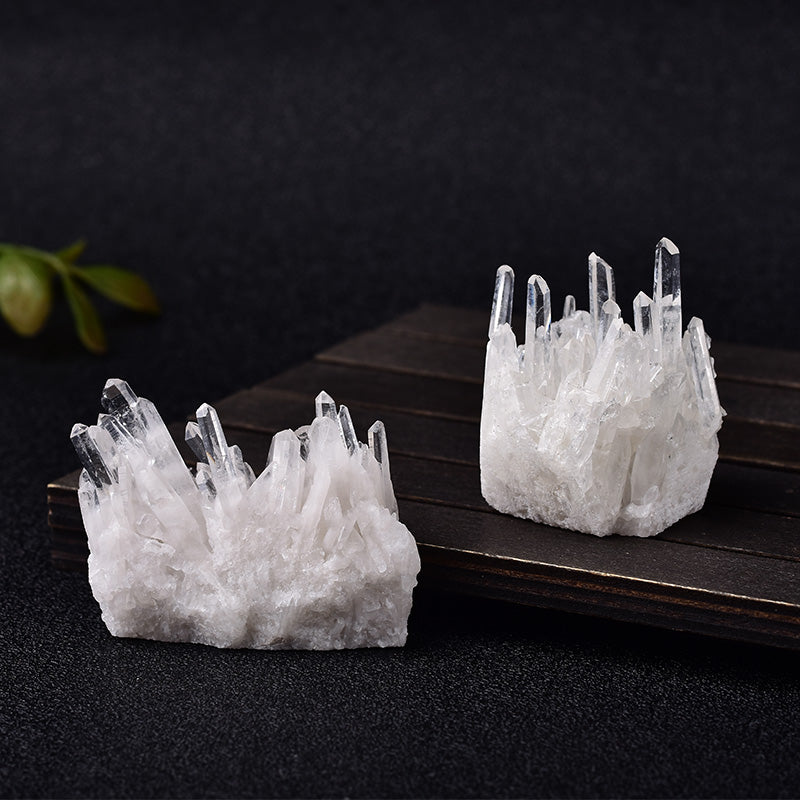 Two crystal formations on a dark surface with a blurred background