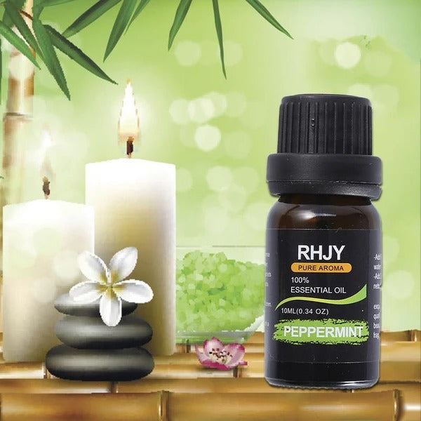 RHJY peppermint essential oil bottle with candles and stones on a green background