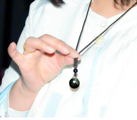 Person holding a necklace with a pendant
