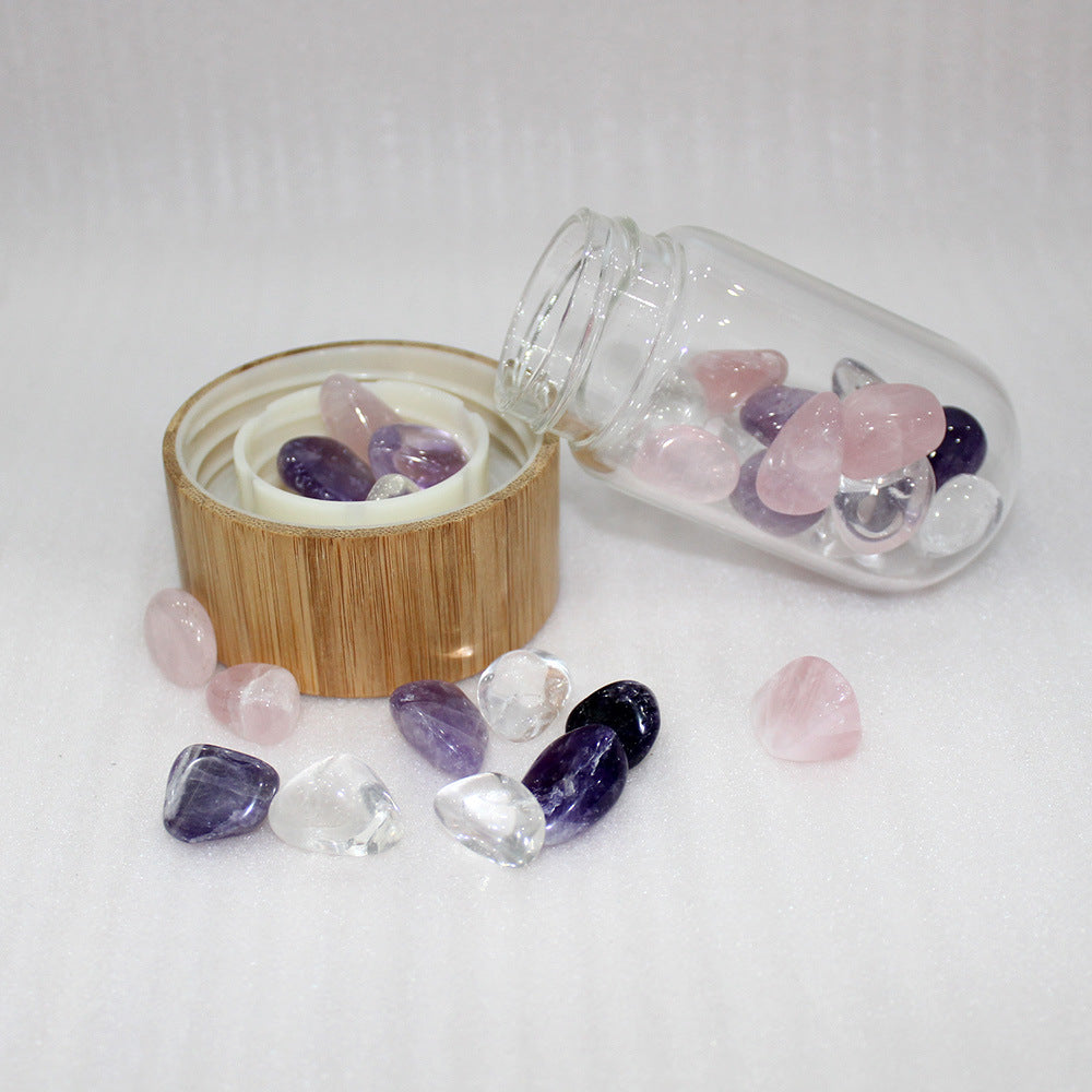 Crystal stones with a wooden container and glass jar on a white background