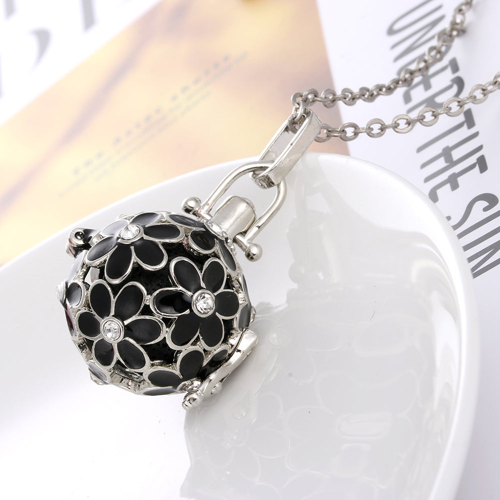 Necklace with a black floral pendant on a white surface