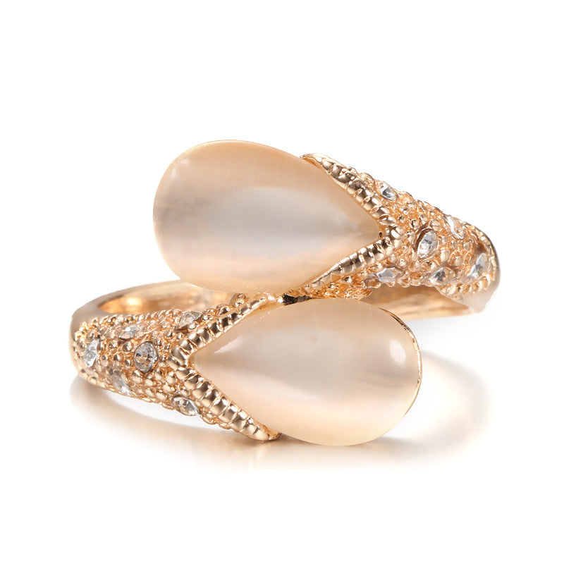 Pair of gold rings with pear-shaped stones on a white background