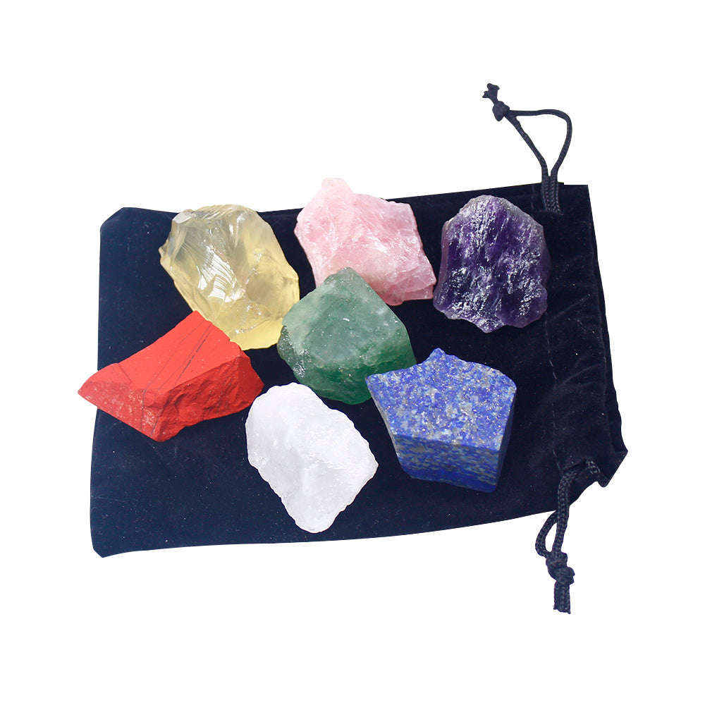 Set of colorful crystals on a black drawstring bag against a white background
