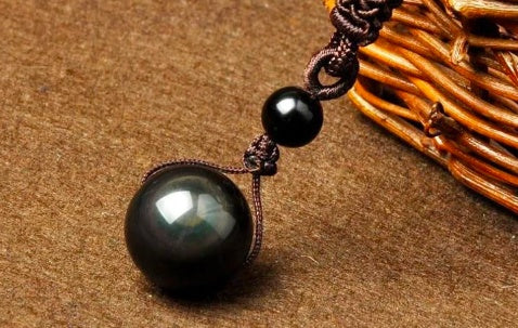 Black beaded necklace on a textured brown surface