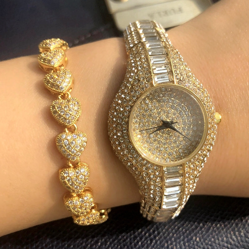Gold watch and bracelet on a wrist with a blurred background