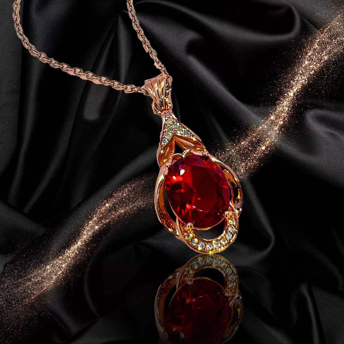 Gold pendant with a red gemstone on a black satin background