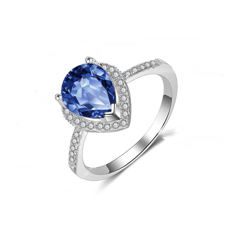 Silver ring with a blue gemstone on a white background
