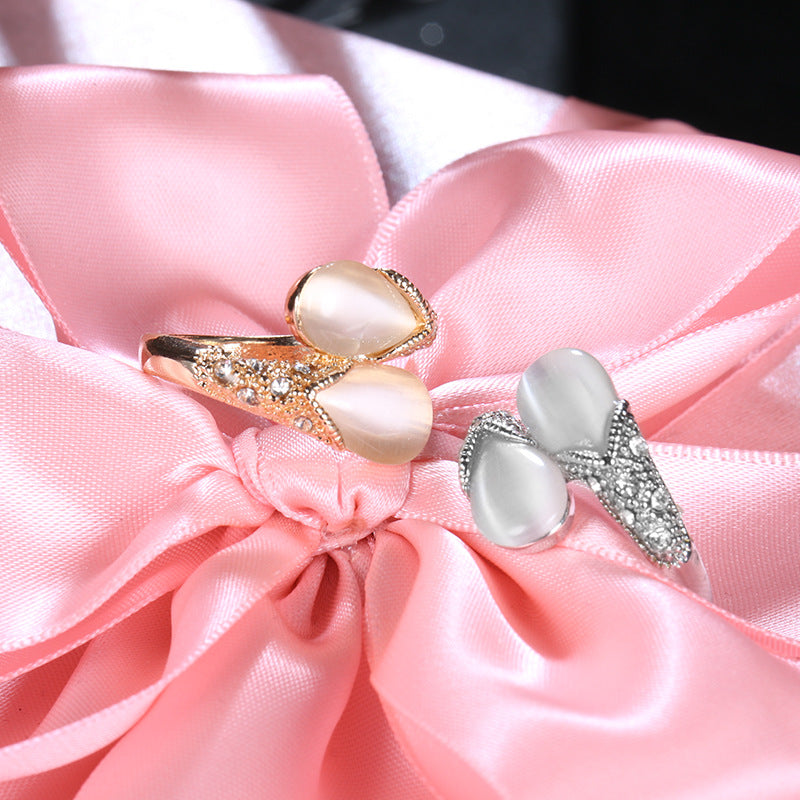 Two pearl rings on a pink satin bow