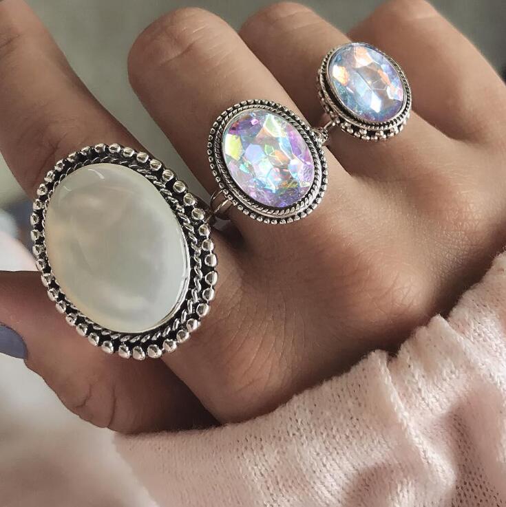 Three ornate rings on a person's hand with a soft background