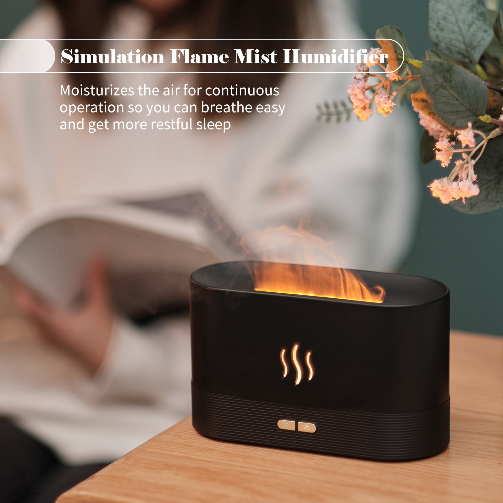 Black flame mist humidifier on a wooden surface with a blurred background of a person reading a book.