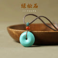 Turquoise pendant necklace with red and blue beads on a wooden surface