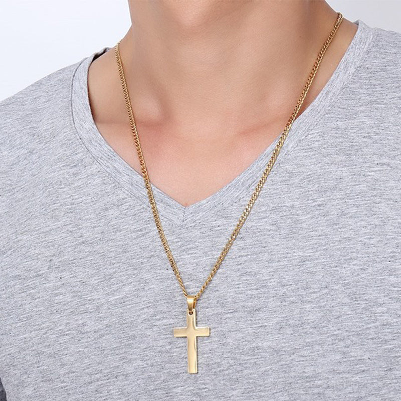 Gold cross necklace on a person wearing a gray shirt