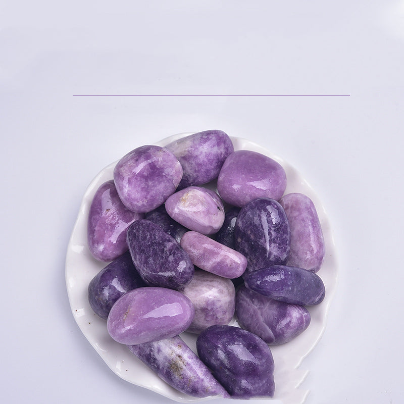 Purple stones on a white plate with a light purple background