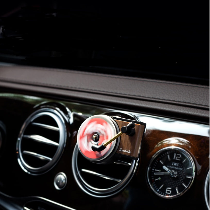 Car air freshener with LED light and clock display on a car dashboard.