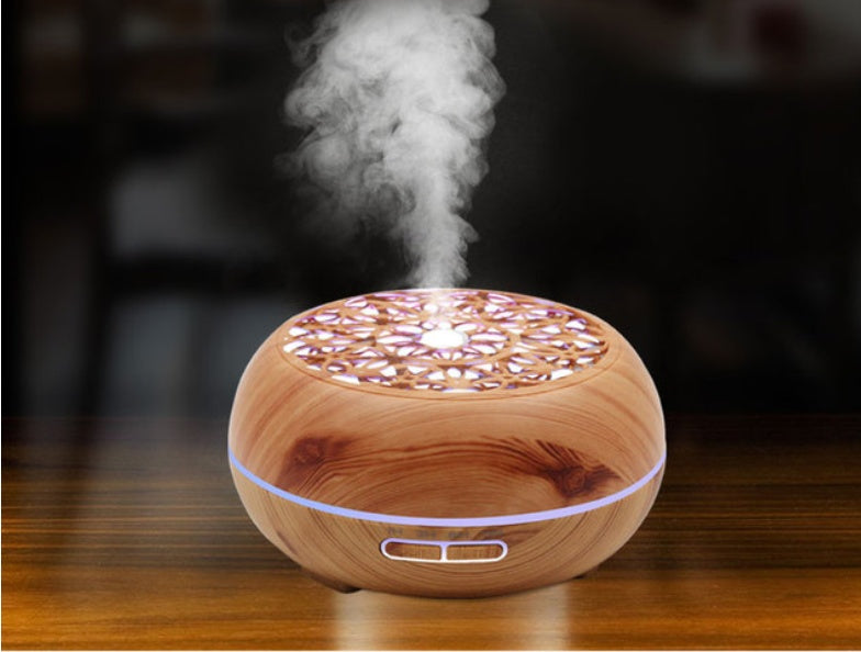Wooden diffuser emitting steam on a dark background