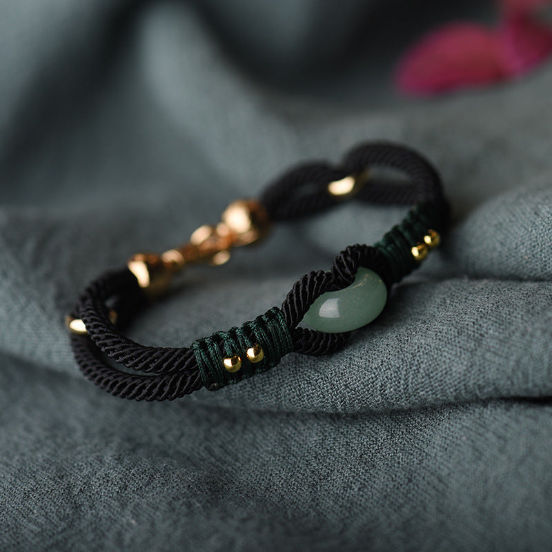 Bracelet with green stone and gold accents on a textured gray surface