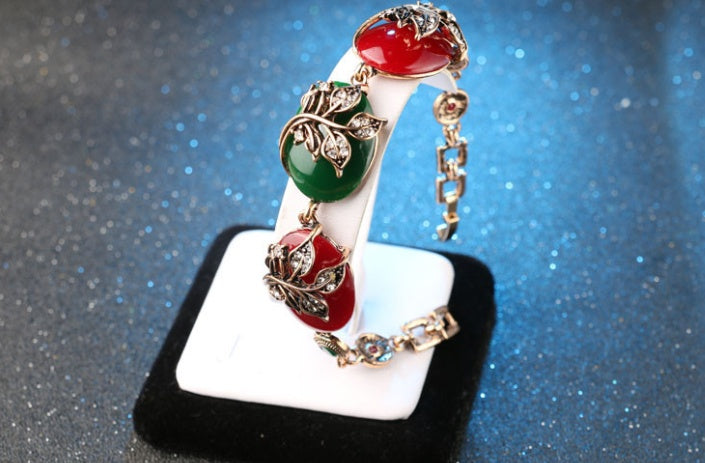 Decorative ring with colorful stones on a white stand against a blue glittery background