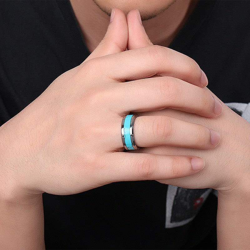 Hand wearing a turquoise ring with a blurred background