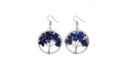 Tree-shaped earrings with blue stones on a white background