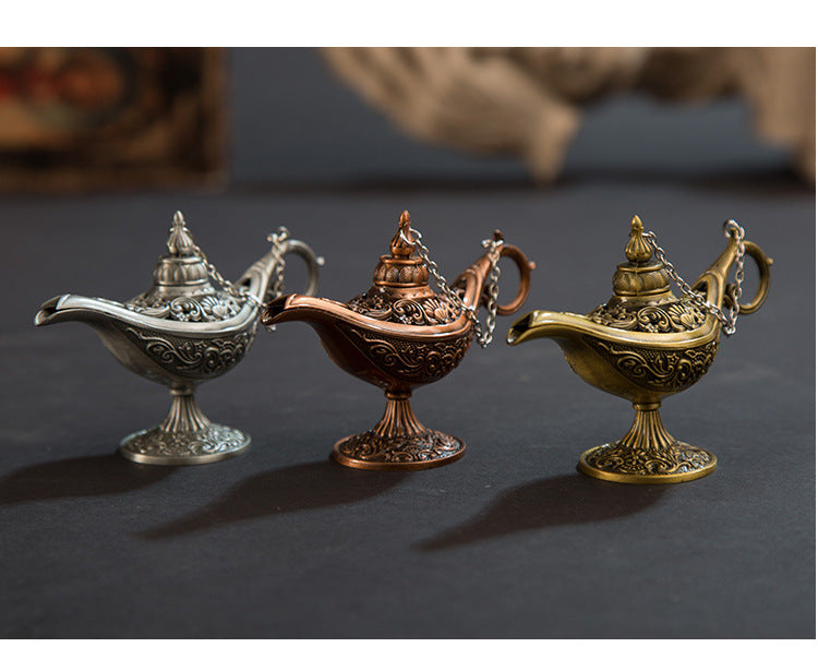 Three ornate lamps in silver, bronze, and gold on a dark background