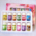 Set of essential oil bottles in a white tray with a pink floral background