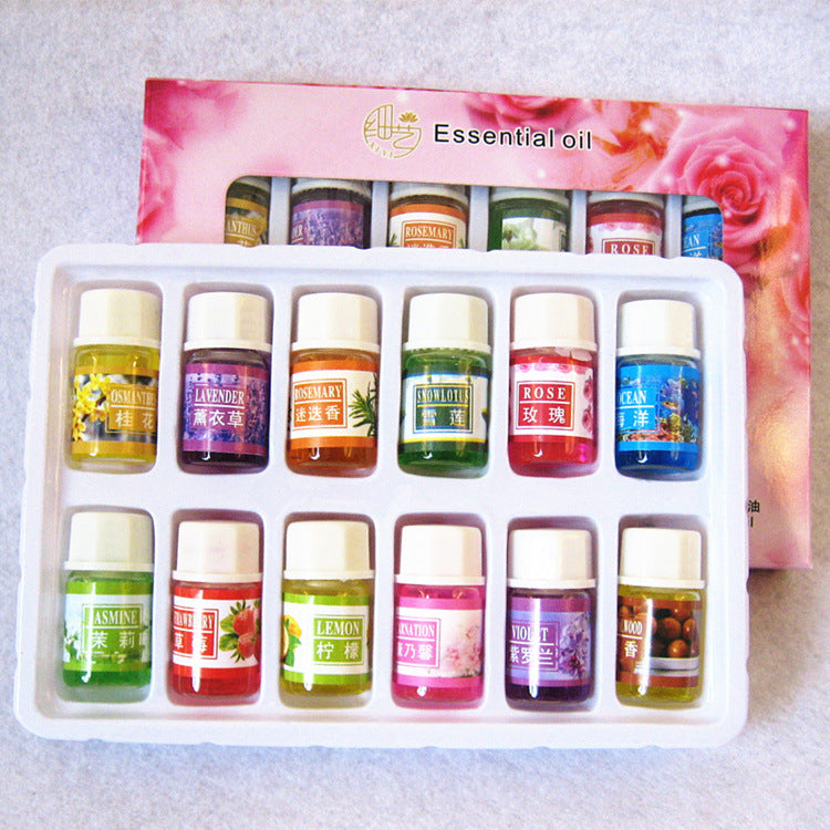 Set of essential oil bottles in a white tray with a pink floral background