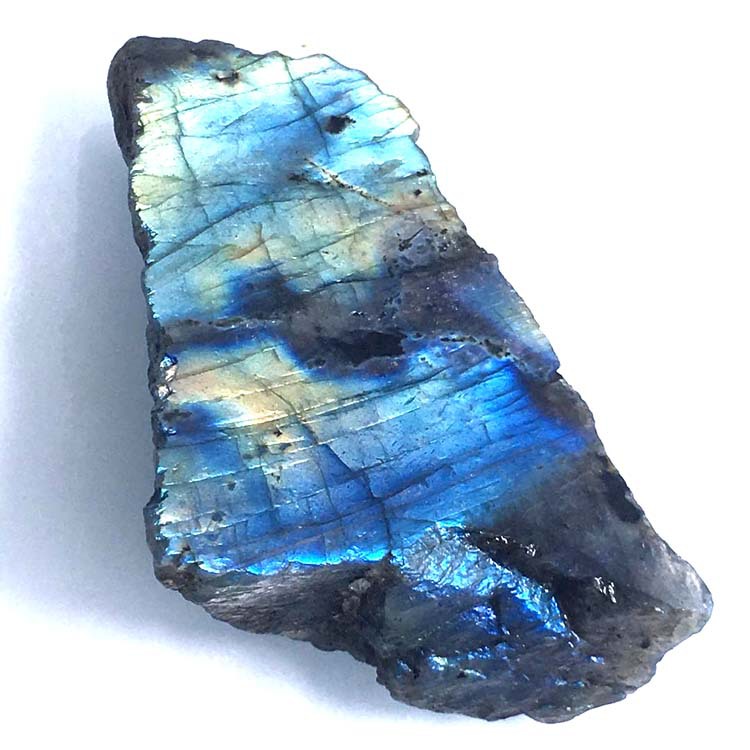 Raw labradorite stone with blue and green colors on a white background