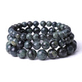 Stack of dark green beaded bracelets on a white background