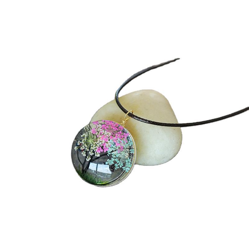 Necklace with a pendant featuring pink flowers on a white background